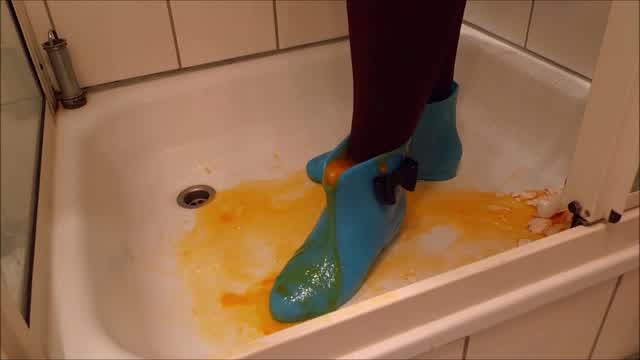 Jana crush and fill eggs in her shiny blue chelsea rubber boots in shower trailer