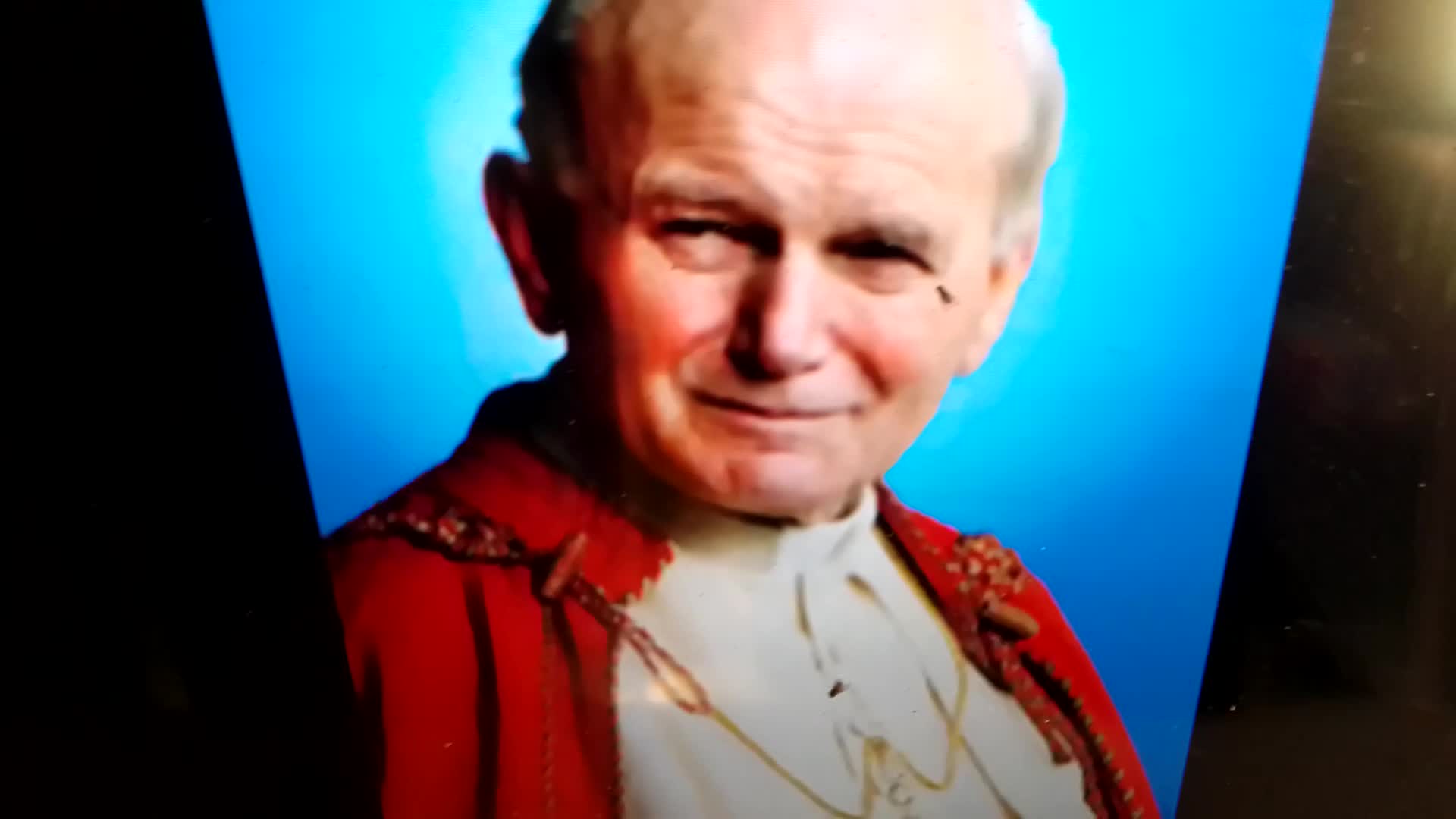 A Polish guy laughs over the clown emoji on John Paul II's face