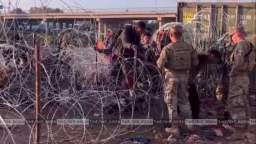 Meanwhile, the US military helps newly arrived foreign specialists get through the barbed wire.