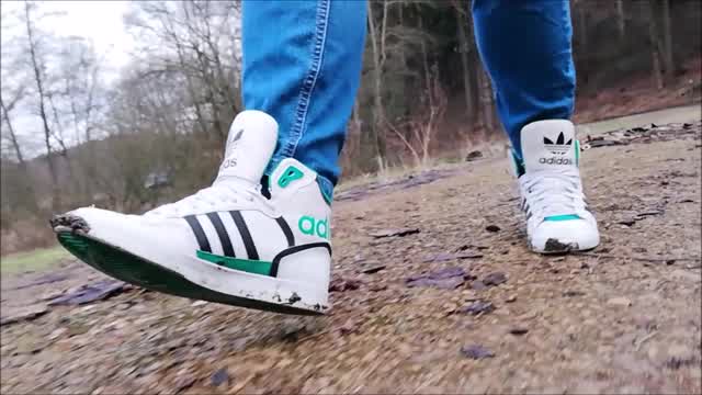 Jana walks through the wet forest with her Adidas Extraball sneakers trailer