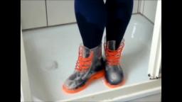 Jana fills washes and squeaks with her transparent rubber boots in the shower trailer