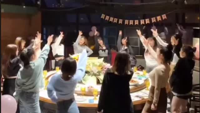 Chinese girls are dancing around the table.